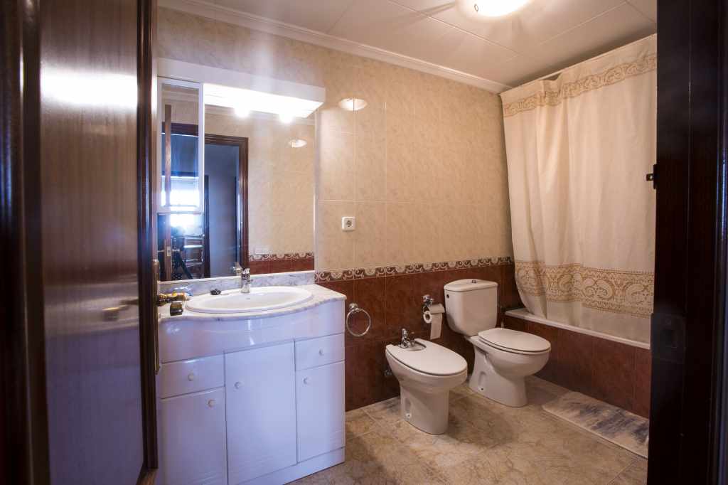 Baño completo con bañera, secador de pelo y toallas