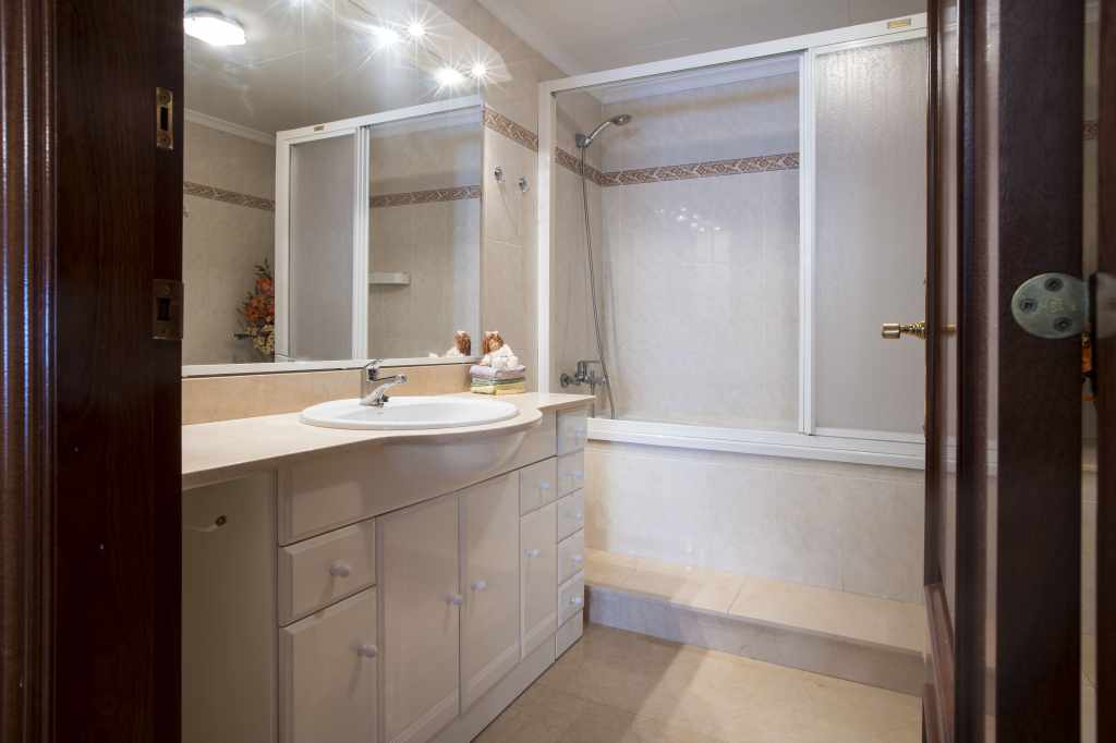 Baño completo con bañera, secador de pelo y toallas