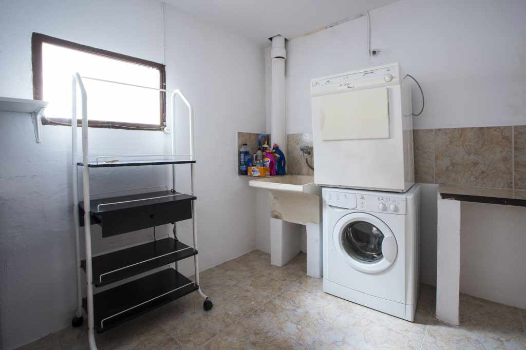 Gran lavadero, con tendedero interior y exterior y lavadora y secadora.