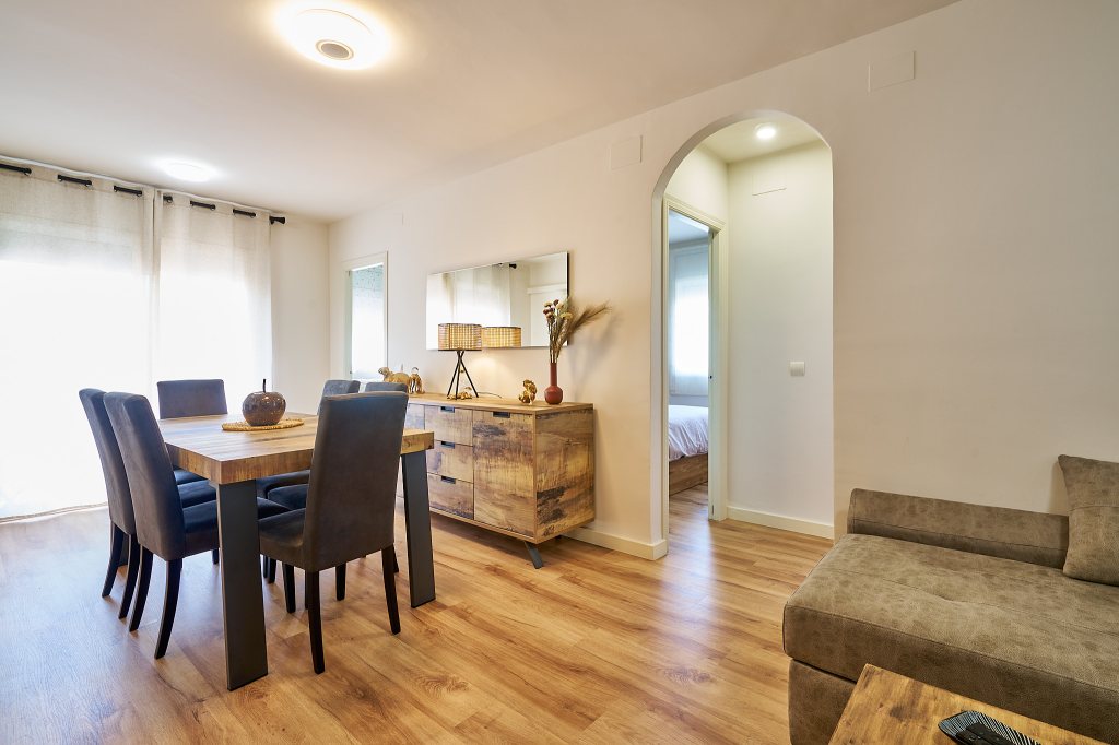 Elegante y confortable comedor con mesa de madera para 6 comensales y salón de estar con televisión