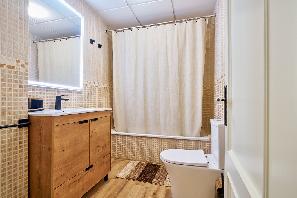 Baño completo, con bañera, toallas y secador de pelo.